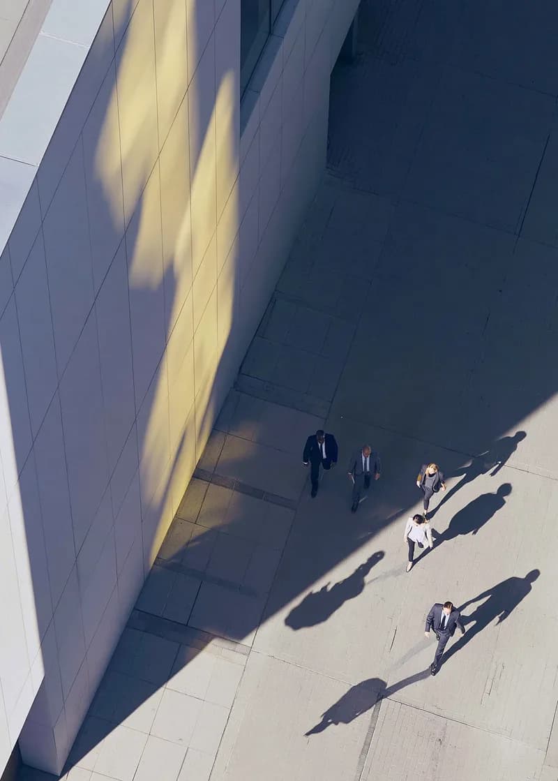 Deal professionals walking beside a modern office building